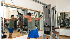 Una palestra con attrezzi, specchi e pavimento in legno.