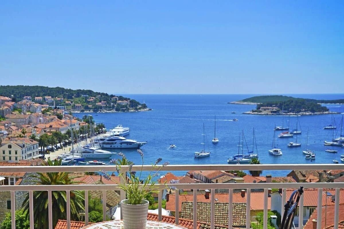 A coastal town with a marina, boats, and a clear view of the sea.