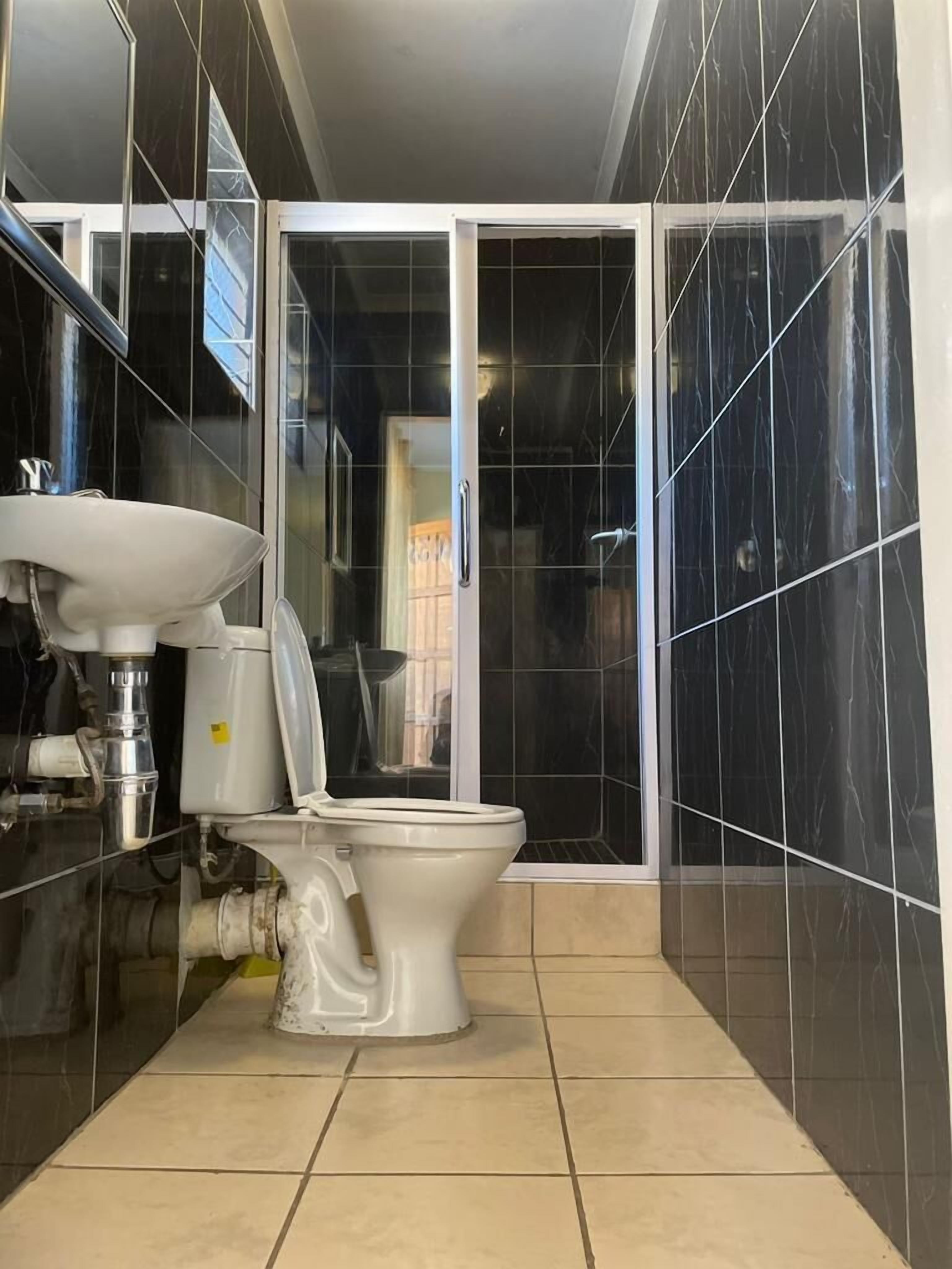 A bathroom with a toilet, sink, and shower area.