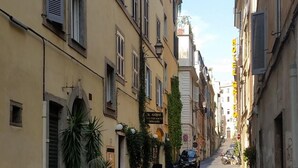 A narrow cobblestone street lined with buildings, a parked motorcycle, and a restaurant named "Il Guru." - Diapason Colosseum Suite (Rome)