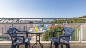 A balcony with two chairs and a table, overlooking a marina and buildings. - Cozy apartment in Ploce with WiFi (Ploce)