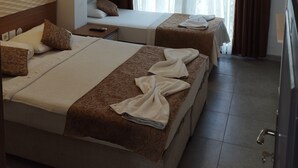 Quarto de hotel com duas camas, televisão e janela com cortinas.