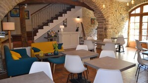 Un intérieur rustique avec des murs en pierre, un escalier et un mélange de meubles modernes et traditionnels.