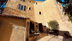 Un bâtiment en pierre doté d’une cour intérieure, avec des espaces de repos en plein air et une petite entrée.