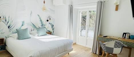 A bedroom with a bed, a desk, and a chair. There is a window with curtains, a wall-mounted air conditioner, and a light fixture.