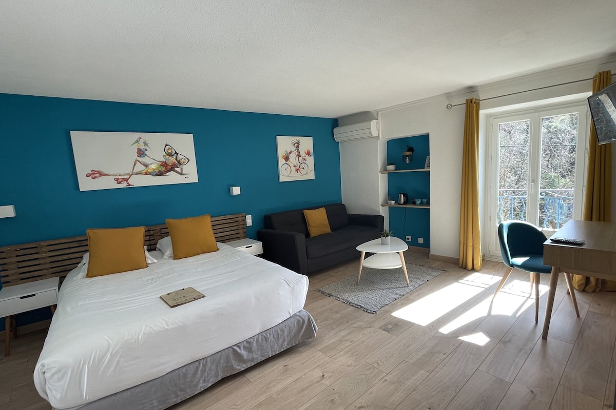 Een moderne hotelkamer met een groot bed, een bank, een kleine tafel en een televisie.