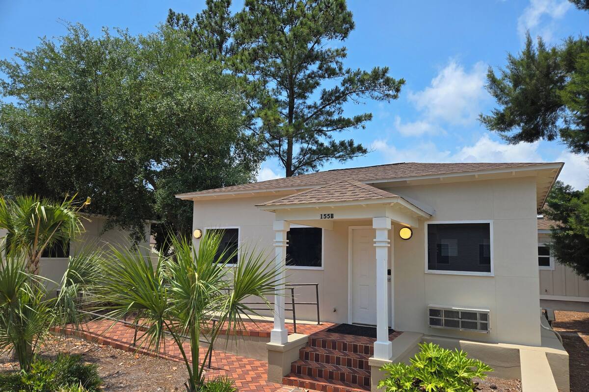 A single-story house with a front porch, a mailbox, and a number '155B' on the door.