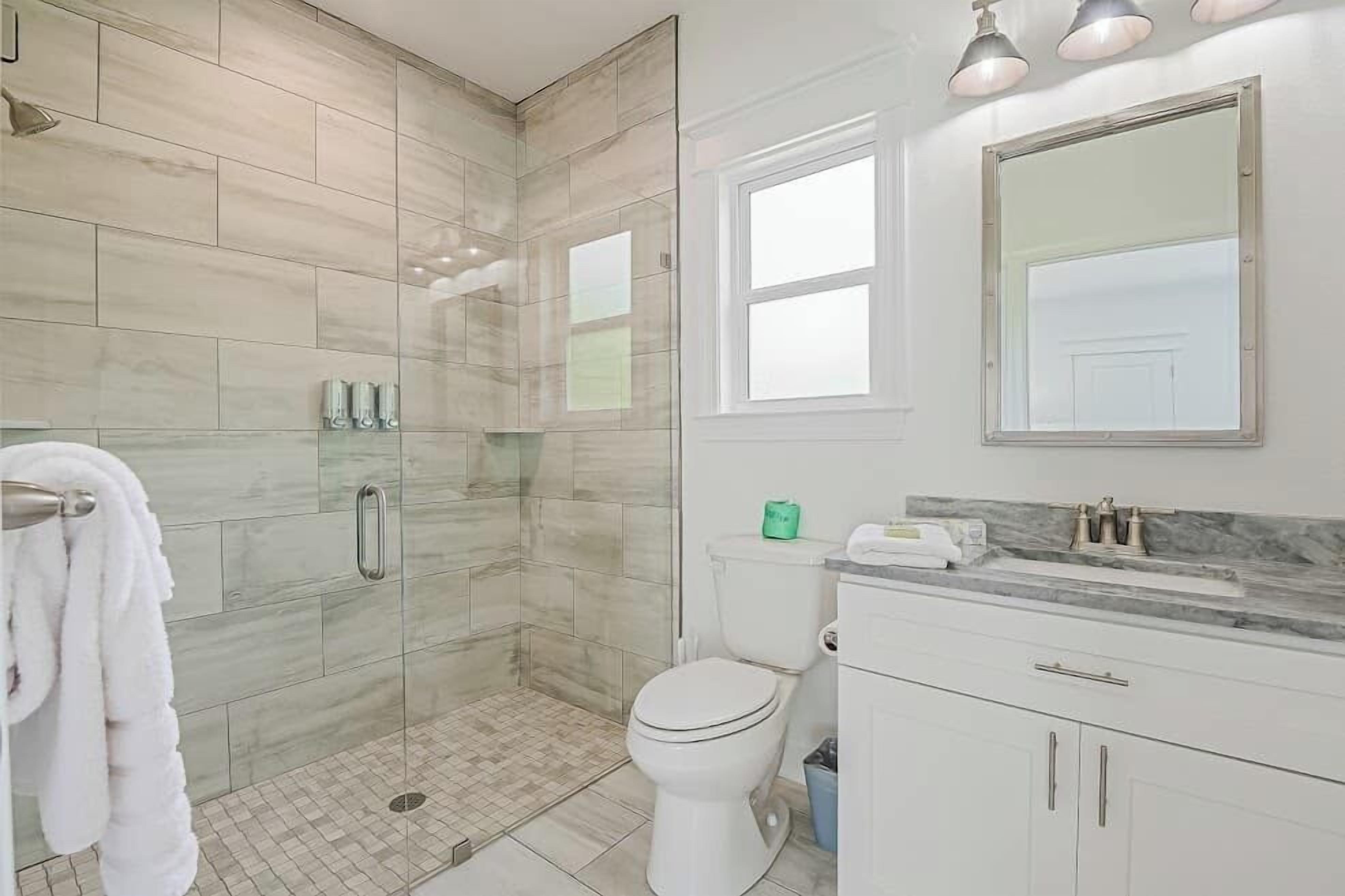 Un baño con ducha, inodoro y zona de lavamanos.