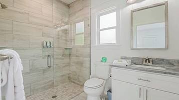Un baño con ducha, inodoro y zona de lavamanos.