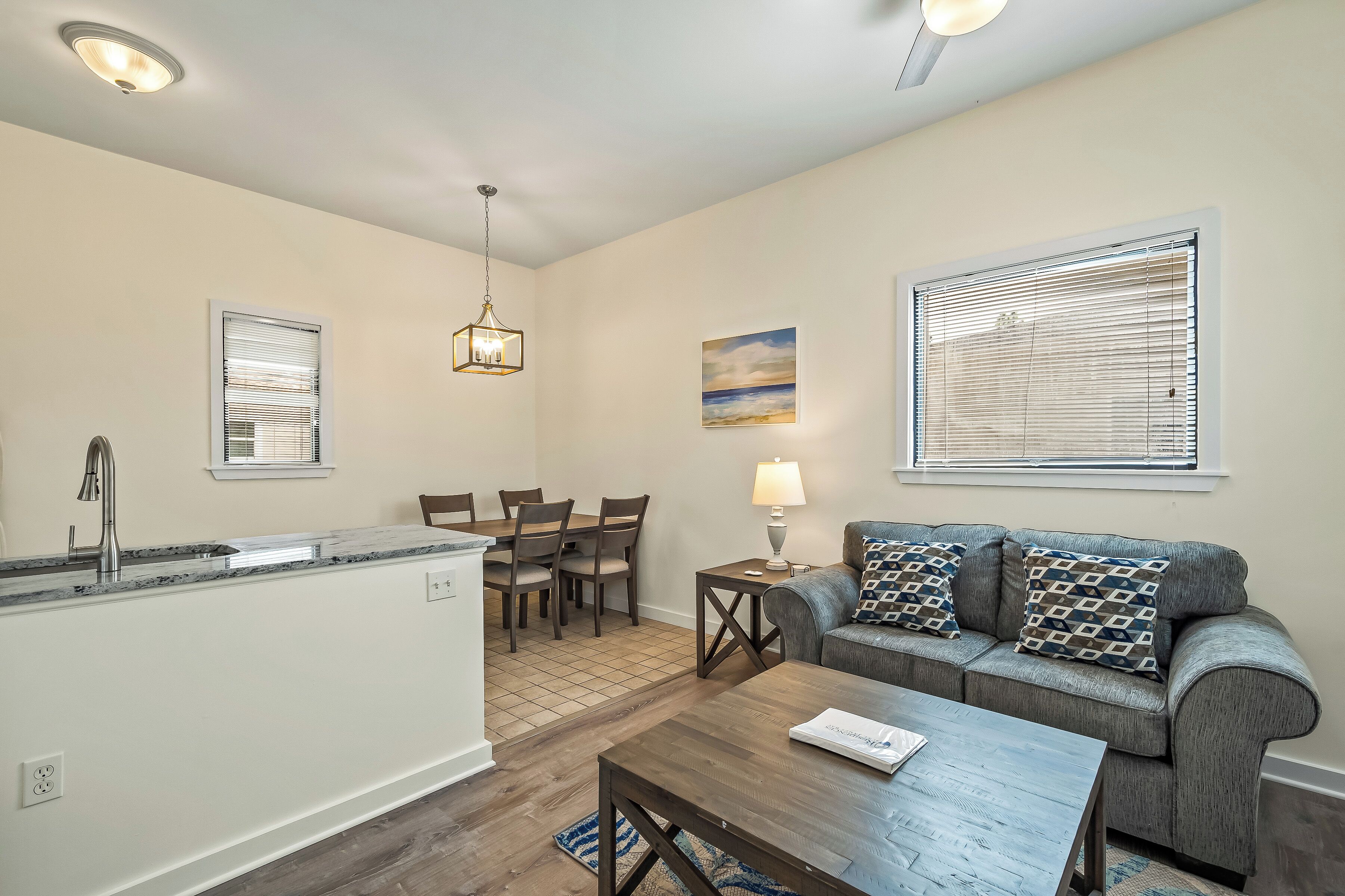 A modern kitchen with a dining area, a sofa, and a coffee table.