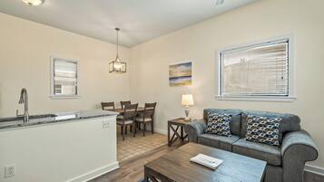 A modern kitchen with a dining area, a sofa, and a coffee table.