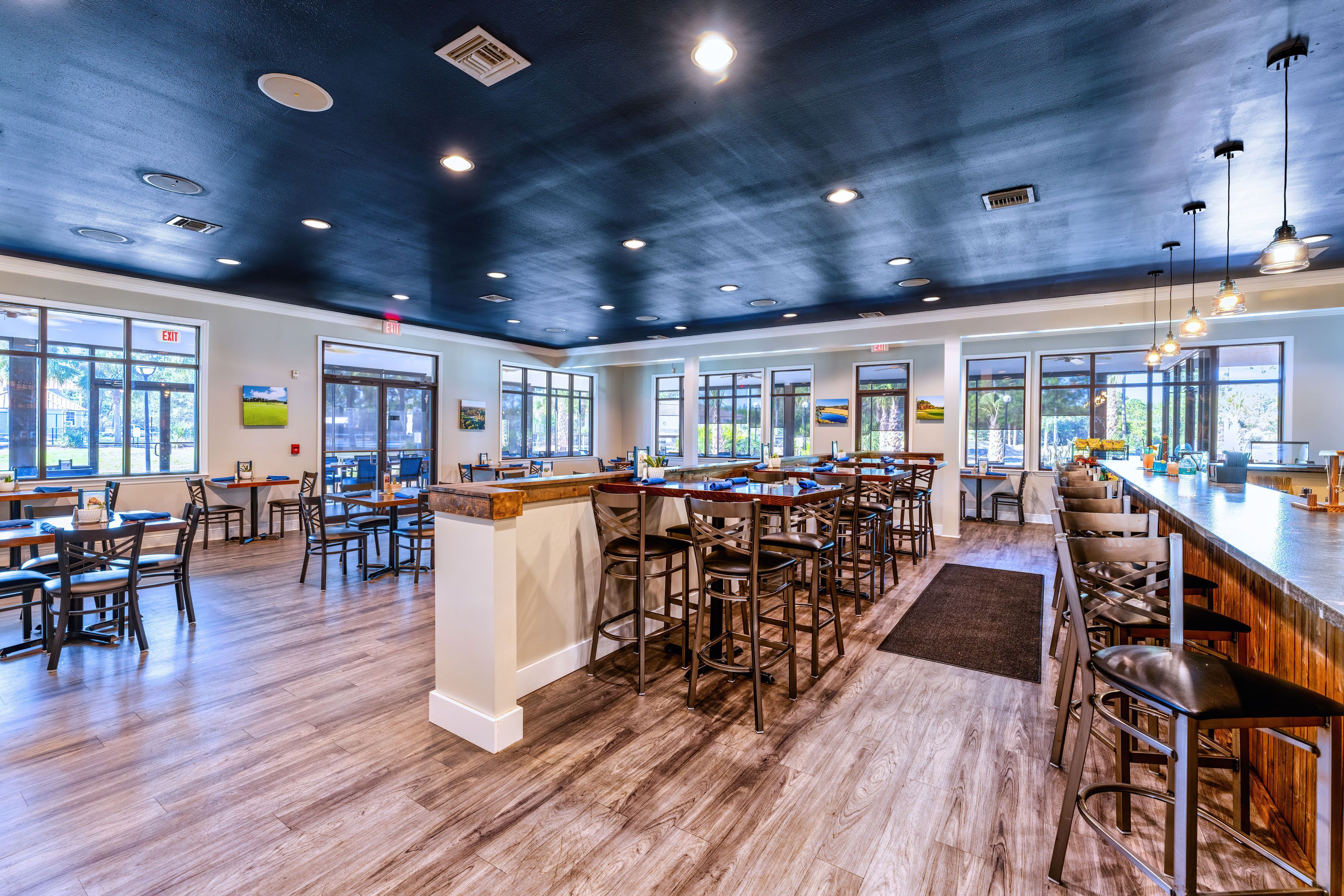 A spacious bar area with high ceilings and natural light from large windows.