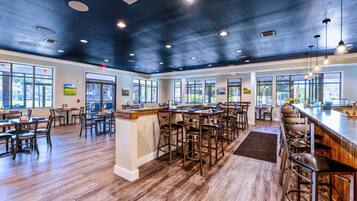 A spacious bar area with high ceilings and natural light from large windows.