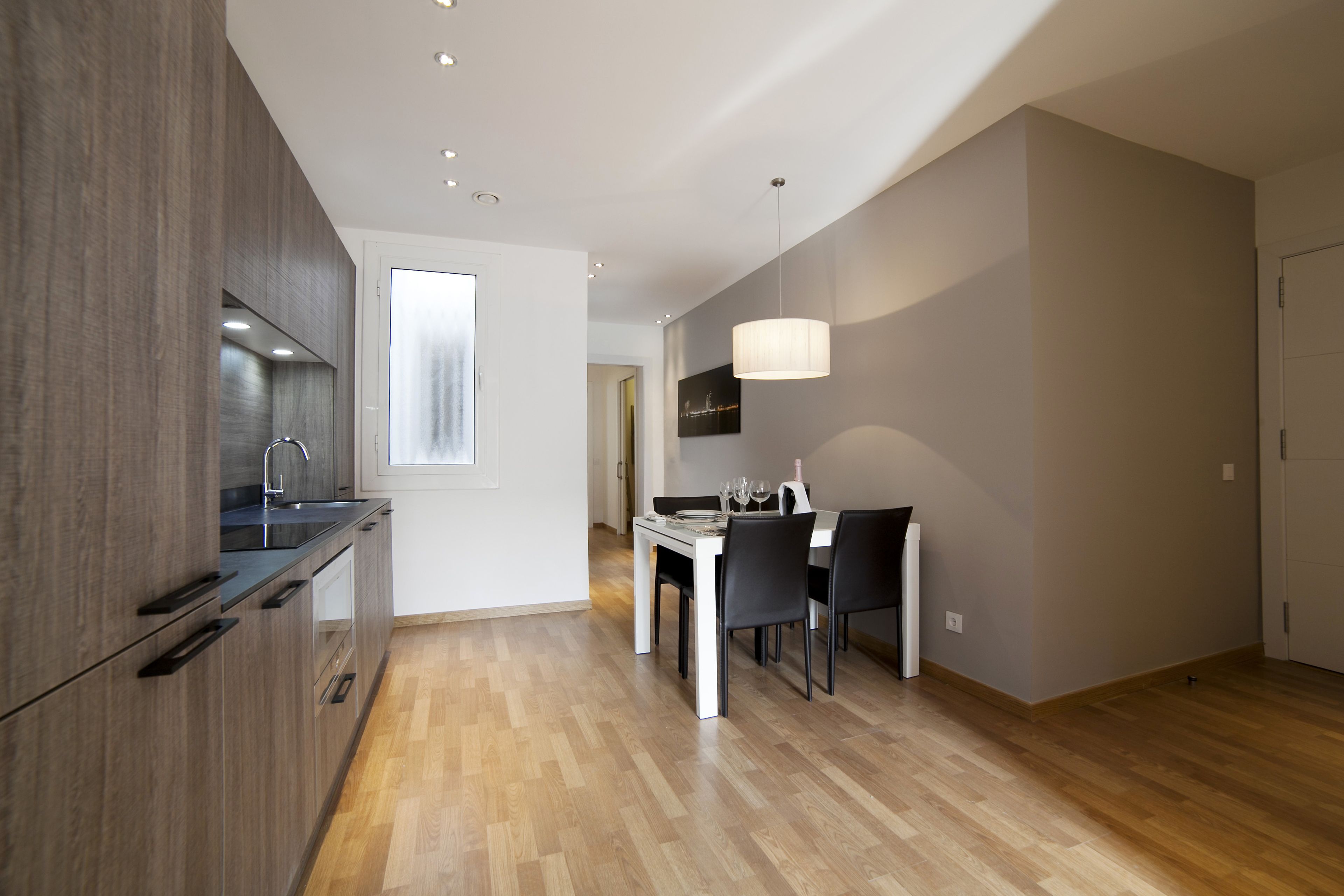 A modern kitchen with dark wood cabinets, a white countertop, and a built-in oven.