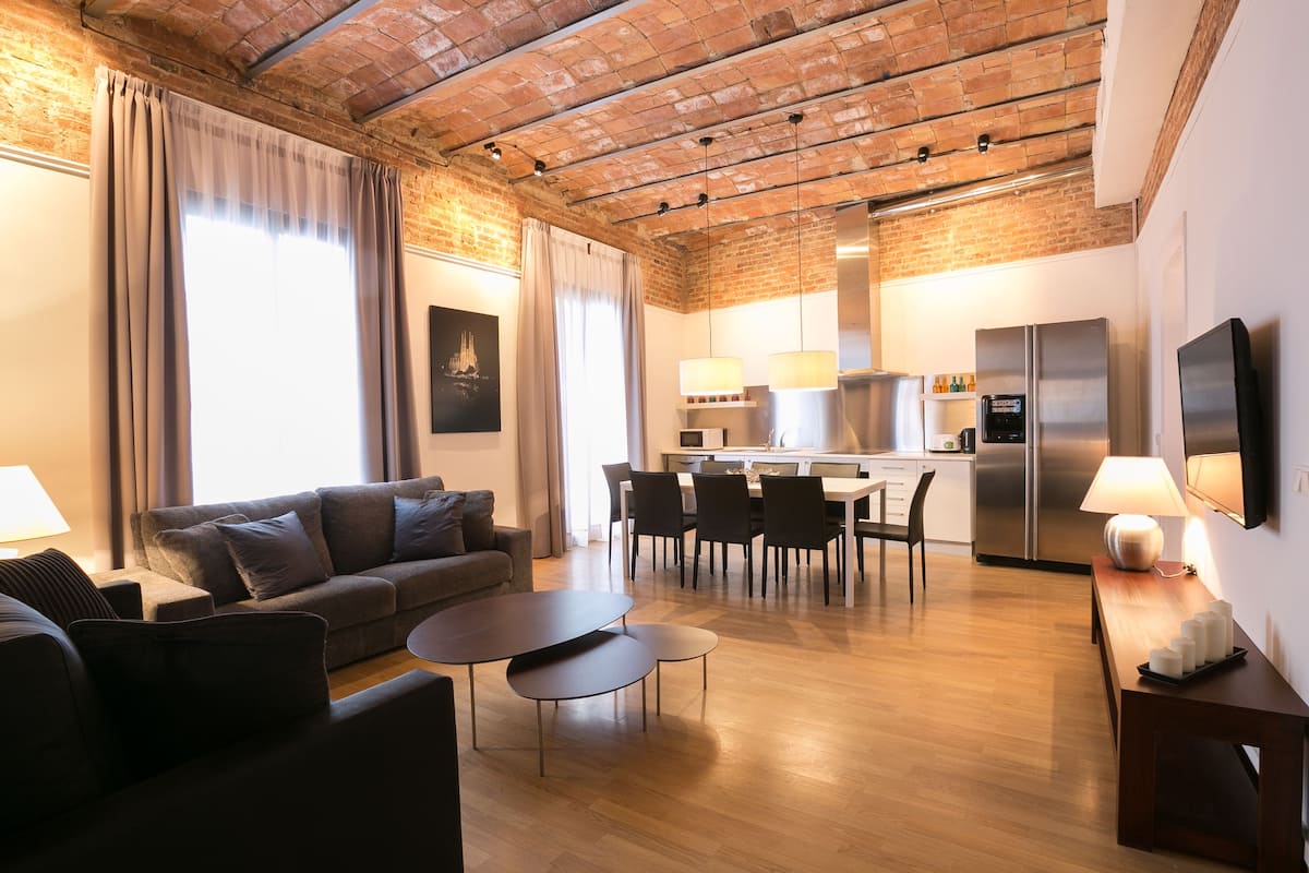 A modern living room with a sofa, coffee table, and dining area.