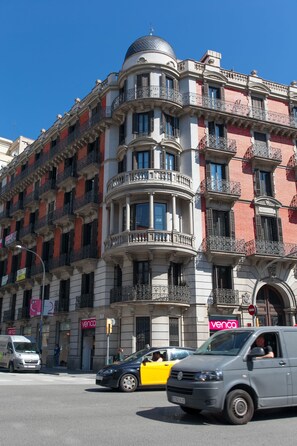 A multi-story building with a curved corner, balconies, and a 'Venco' sign. - Serennia Apartments Ramblas-Pl.Catalunya (Barcelona)