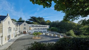 A hotel with a central courtyard, outdoor seating, and a view of surrounding greenery. - Fermain Valley Hotel (St. Peter Port)