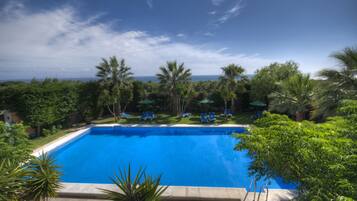Una piscina al aire libre, tumbonas