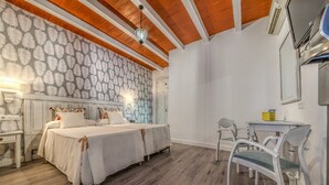 Une chambre avec deux lits, un bureau et des chaises.