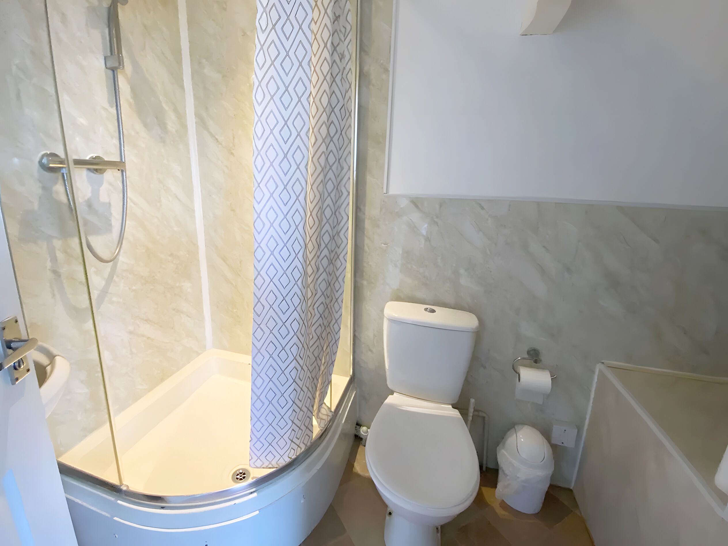 Un baño con ducha, inodoro y lavamanos.