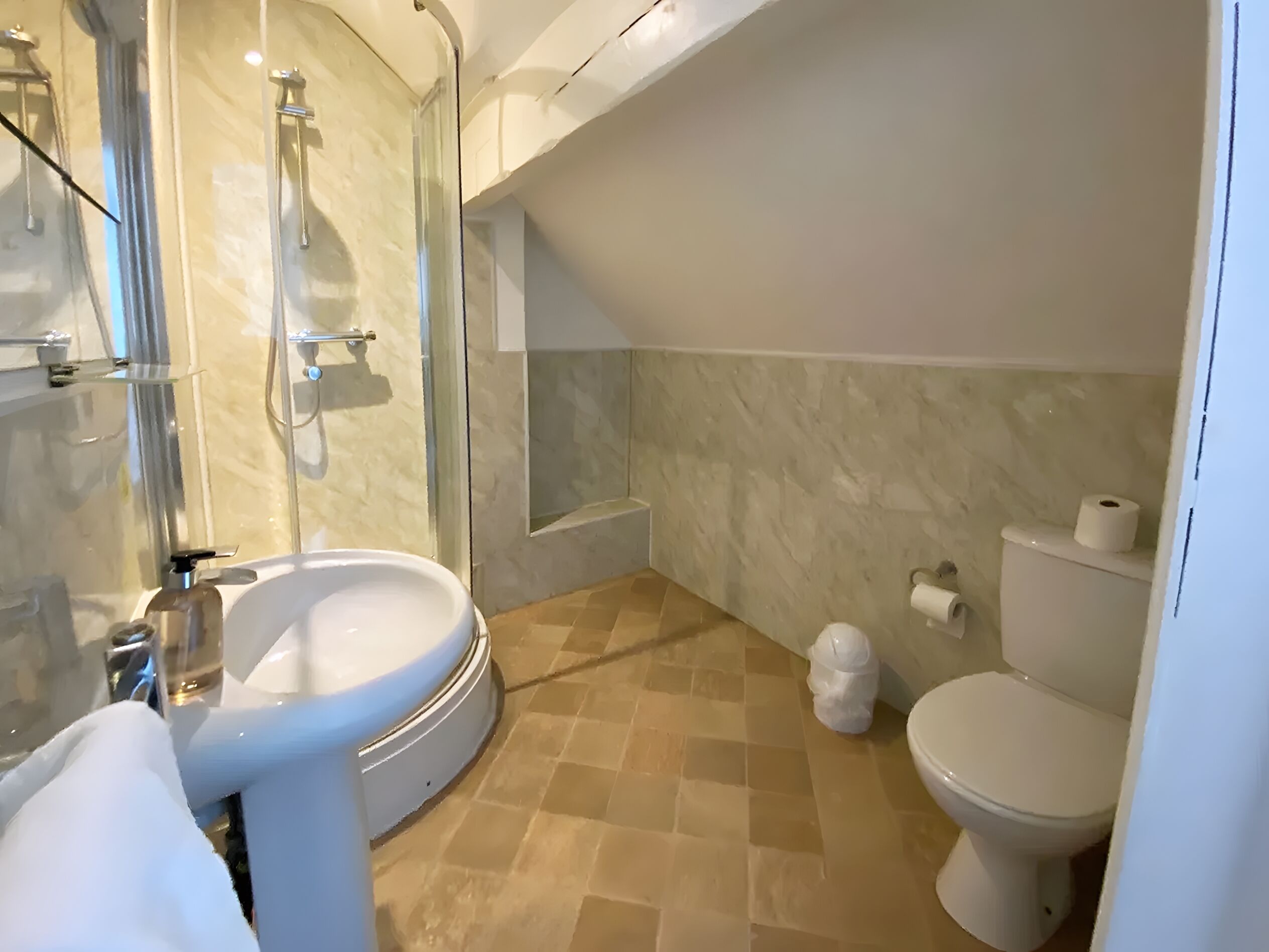 A modern bathroom with a glass-enclosed shower, a sink, a toilet, and a bathtub.