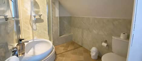 A modern bathroom with a glass-enclosed shower, a sink, a toilet, and a bathtub.