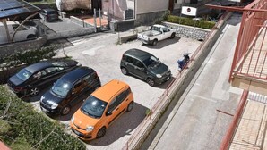 A parking area with multiple cars, a white pickup truck, and a scooter. - Relais Milò (Agerola)