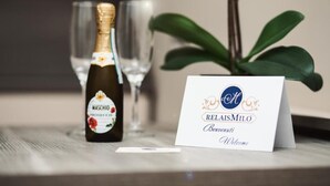 Une bouteille de vin mousseux Maschio Prosecco, un verre et une carte de bienvenue pour RelaisMilò.