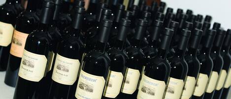 A row of wine bottles with labels, arranged on a table.