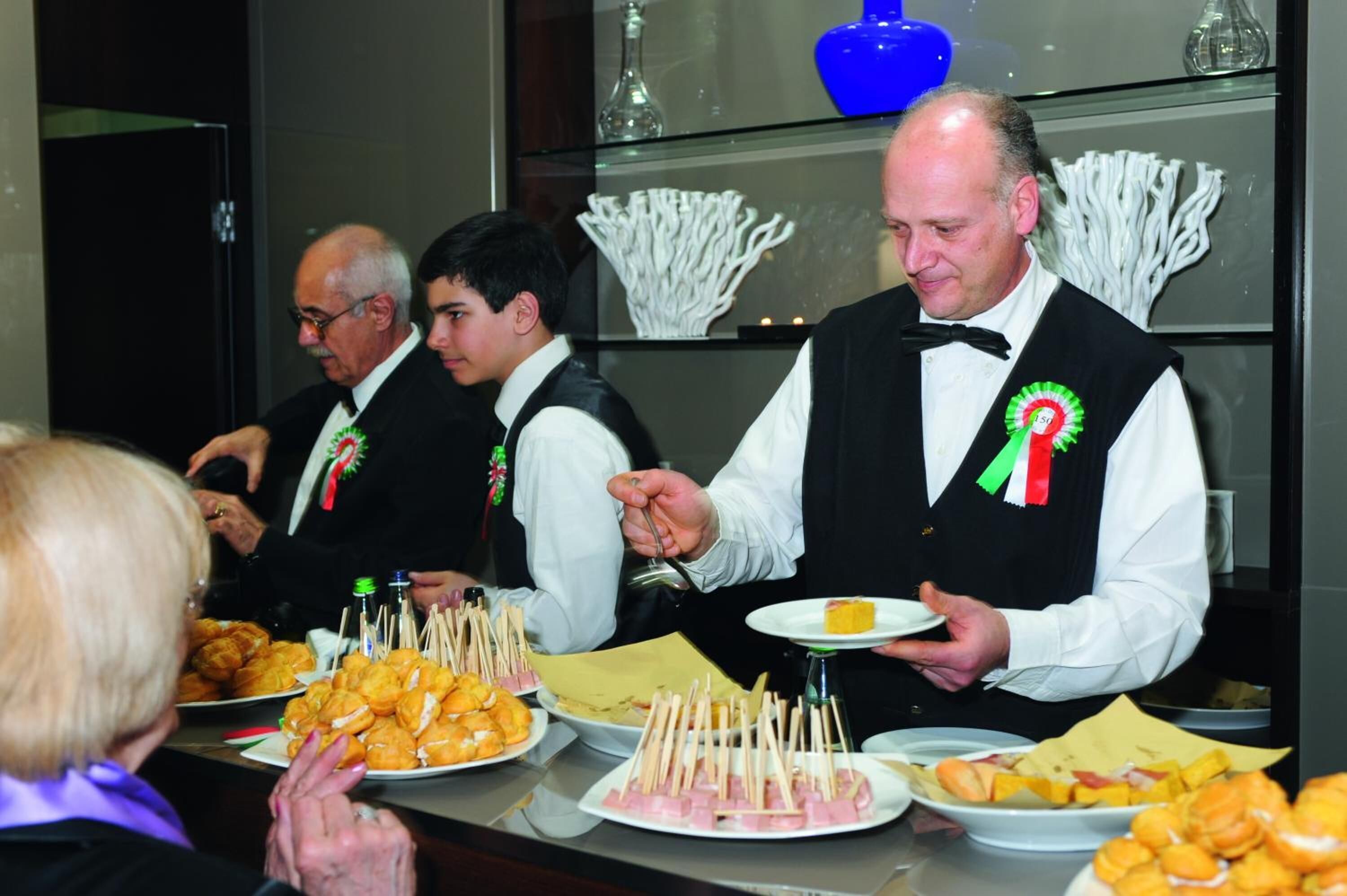 A buffet setup with various food items and a person serving.