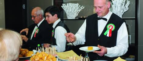 A buffet setup with various food items and a person serving.