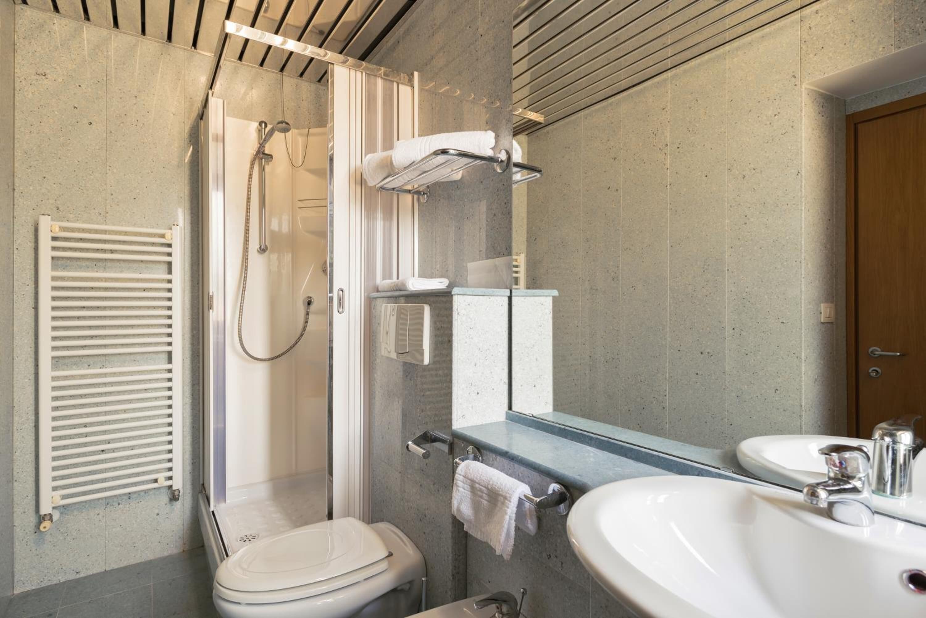 Une salle de bain moderne équipée d’une douche, de toilettes et d’un lavabo.