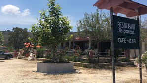 A restaurant sign with outdoor seating, surrounded by trees and a clear sky. - Daphne's Boutique Apartments (Kefalonia)