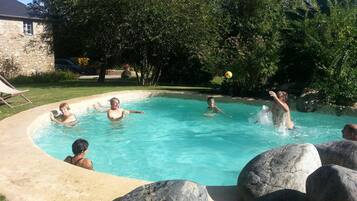 Una piscina al aire libre de temporada, sombrillas