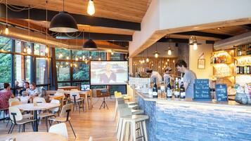 A restaurant with wooden interiors, bar area, and outdoor seating.