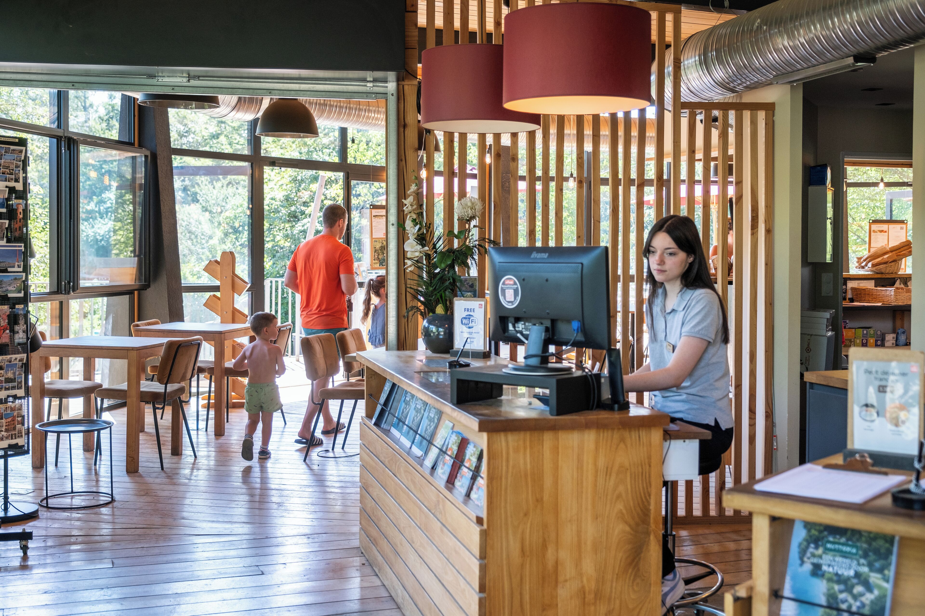 A wooden interior with a reception desk, chairs, and a large window.