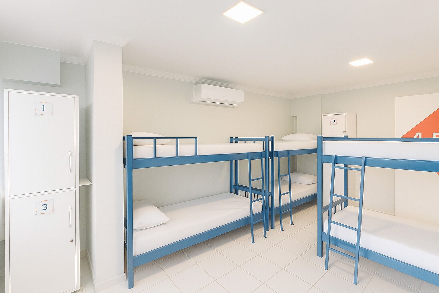 A dormitory room with bunk beds, a wardrobe, and an air conditioning unit.