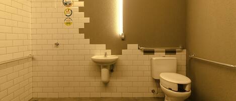 Un baño pequeño con azulejos, un lavabo, un inodoro y un asidero.