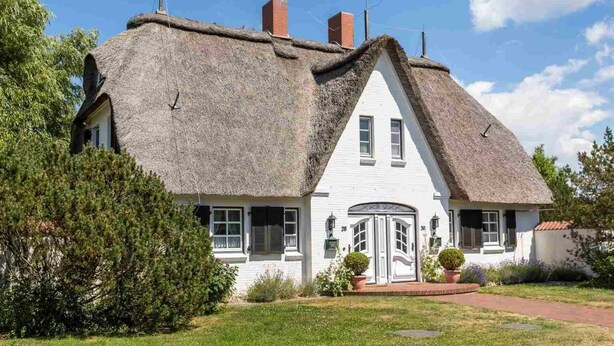A white house with a steeply pitched thatched roof and a small porch with potted plants. - Holiday house Witte Hus (ID 175) - Holiday house "Witte Hus" (ID 175) (Sankt Peter-Ording)