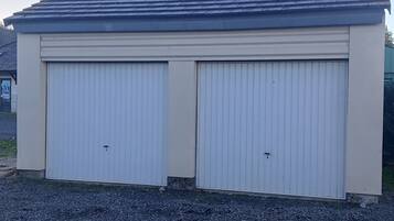 Eine Garage für zwei Autos mit geneigtem Dach und sandfarbenem Anstrich.