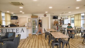 Un café doté d’un espace d  ’accueil, de sièges et d’un réfrigérateur.