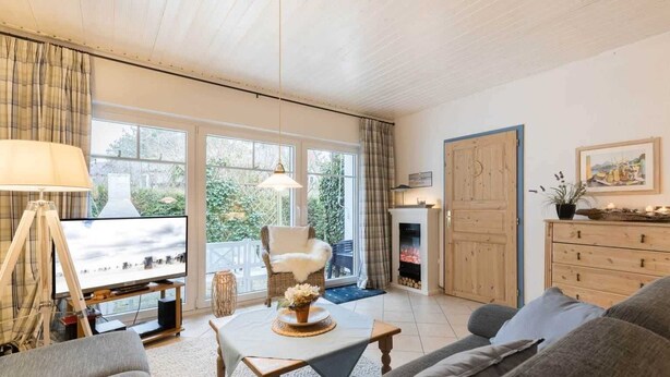 A cozy living room with a fireplace, a television, and a comfortable seating area. - House 7 "Beach Pirate" (ID 023) (Room category) - House 7 "Beach Pirate" (ID 023) (Sankt Peter-Ording)