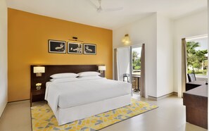 Una habitación de hotel con una cama grande, un ventilador de techo y vistas al exterior.