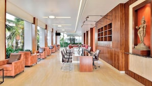 A spacious lobby with a long reception desk, comfortable seating, and a statue on the wall. - Four Points by Sheraton Mahabalipuram Resort & Convention Center (Tirukalukundram)