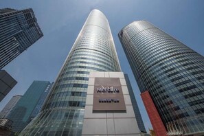 A tall, modern building with a glass facade and a sign that reads 'Mercure.' - Mercure Hangzhou Qianjiang (Hangzhou)