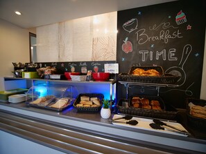 A breakfast buffet area with various food items and a chalkboard sign that reads "Breakfast Time". - ibis budget Chartres (Chartres)