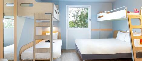 A bunk bed room with a window, a desk, and a chair.