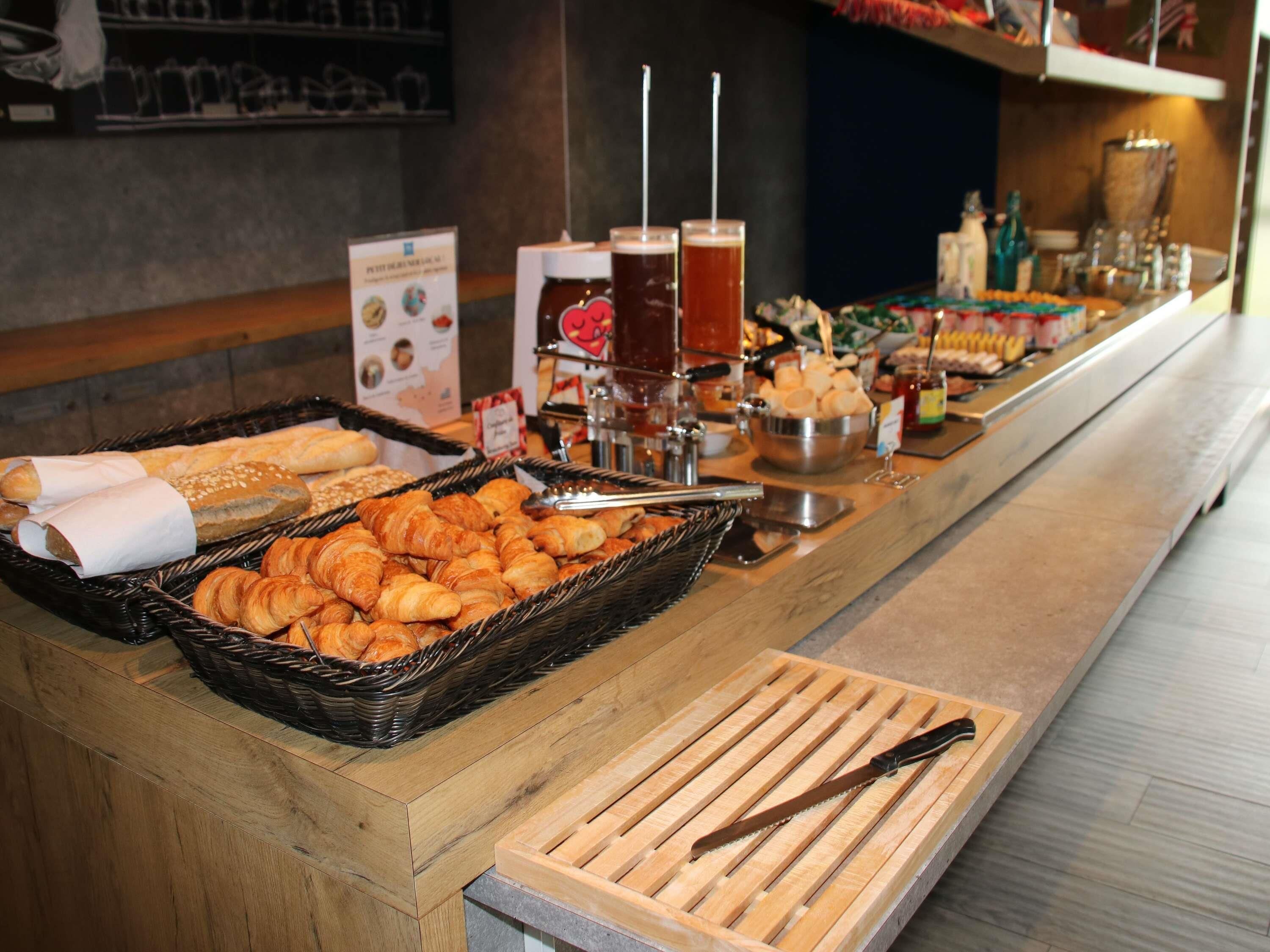Un buffet proposant une variété de produits de boulangerie, de boissons et de condiments.