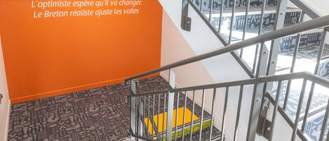 Una escalera con barandilla de metal y baldosas de suelo decoradas.