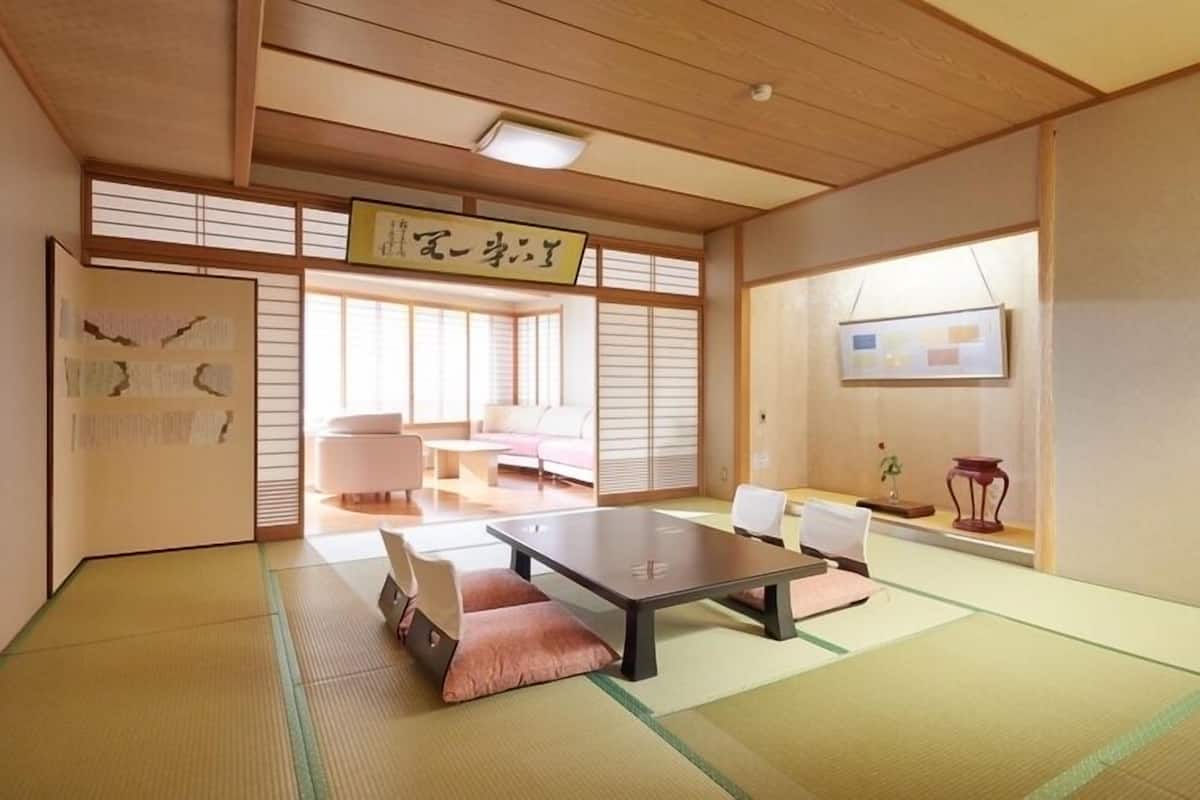 Ein traditioneller japanischer Raum mit Tatami-Boden, einem niedrigen Tisch und Schiebetüren.